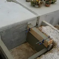 Coffrage en bois et maçonnerie pour la construction d'un monument funéraire.