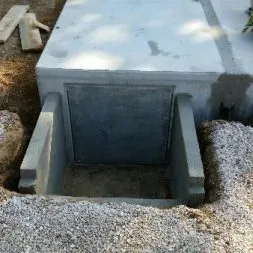 Soubassement en béton d'un monument funéraire en construction dans un cimetière.